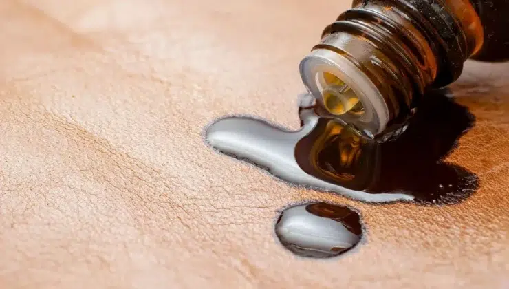 A small bottle of castor oil spilled on a piece of cloth to make a castor oil pack.