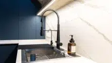 Large modern workstation sink in blue kitchen
