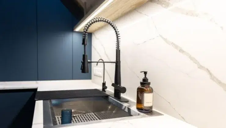 Large modern workstation sink in blue kitchen